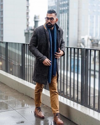 Come indossare e abbinare una sciarpa blu per un uomo di 30 anni quando fa gelo in modo smart-casual: Scegli un soprabito grigio scuro e una sciarpa blu per un'atmosfera casual-cool. Rifinisci il completo con un paio di stivali casual in pelle marroni.