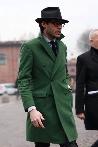 Un uomo che indossa un cappotto verde e occhiali da sole foto
