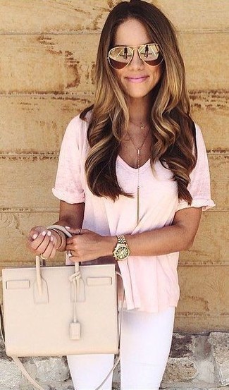 Come indossare e abbinare una t-shirt con scollo a v rosa: Mostra il tuo stile in una t-shirt con scollo a v rosa con jeans aderenti bianchi per un outfit comodo ma studiato con cura.