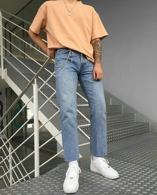 Come indossare e abbinare una t-shirt arancione per un uomo di 20 anni: Coniuga una t-shirt arancione con jeans azzurri per un outfit comodo ma studiato con cura. Scegli un paio di sneakers basse in pelle bianche come calzature per un tocco virile.