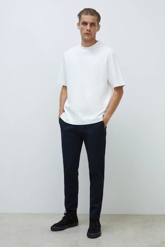 Look alla moda per uomo: T-shirt girocollo bianca, Chino blu scuro, Sneakers alte di tela nere