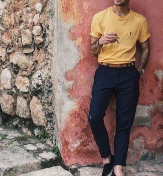 Look alla moda per uomo: T-shirt girocollo gialla, Chino blu scuro, Espadrillas di tela nere, Cintura in pelle terracotta