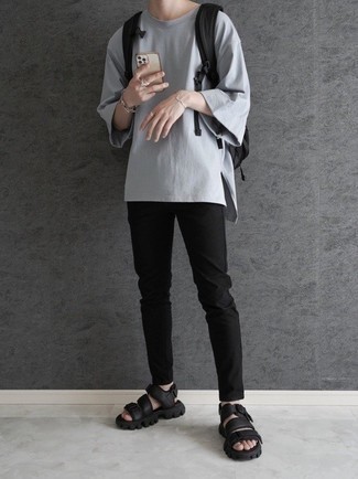 Moda uomo anni 20 quando fa molto caldo: Combina una t-shirt girocollo grigia con chino neri per vestirti casual. Per un look più rilassato, scegli un paio di sandali in pelle neri.