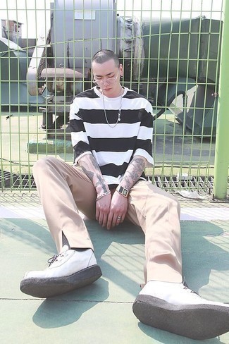 Look alla moda per uomo: T-shirt girocollo a righe orizzontali bianca e nera, Chino beige, Sneakers basse di tela bianche, Occhiali da sole trasparenti