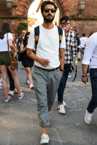 Look alla moda per uomo: T-shirt girocollo bianca, Chino grigi, Sneakers basse di tela bianche, Zaino di tela blu scuro