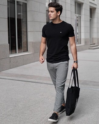 Look alla moda per uomo: T-shirt girocollo nera, Chino grigi, Sneakers basse in pelle nere, Borsa shopping di tela stampata nera e bianca