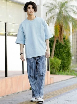 Look alla moda per uomo: T-shirt girocollo azzurra, Chino a righe verticali blu scuro, Sneakers basse di tela bianche, Bracciale dorato