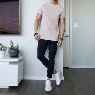 Come indossare e abbinare una t-shirt girocollo rosa con chino blu scuro per un uomo di 30 anni: Indossa una t-shirt girocollo rosa con chino blu scuro per un look trendy e alla mano. Sneakers basse in pelle bianche sono una buona scelta per completare il look.