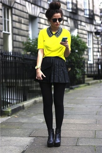 Come indossare e abbinare una gonna a pieghe nera: Coniuga una t-shirt girocollo gialla con una gonna a pieghe nera per una sensazione di semplicità e spensieratezza. Questo outfit si abbina perfettamente a un paio di stivaletti in pelle neri.