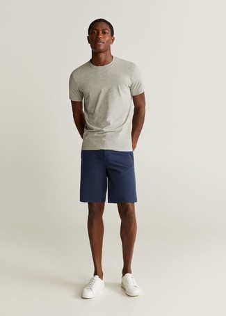 Look alla moda per uomo: T-shirt girocollo grigia, Pantaloncini blu scuro, Sneakers basse in pelle bianche