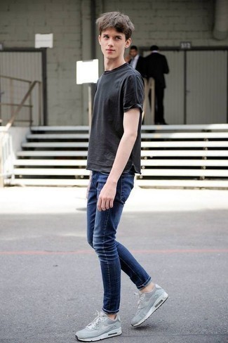 Come indossare e abbinare scarpe sportive grigie per un uomo di 17 anni: Indossa una t-shirt girocollo grigio scuro e jeans blu scuro per vestirti casual. Per distinguerti dagli altri, scegli un paio di scarpe sportive grigie come calzature.