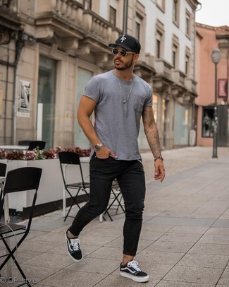 Come indossare e abbinare jeans aderenti neri per un uomo di 30 anni: Combina una t-shirt girocollo grigia con jeans aderenti neri per un outfit rilassato ma alla moda. Sneakers basse di tela nere e bianche doneranno eleganza a un look altrimenti semplice.