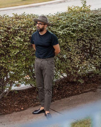 Moda uomo anni 40: Indossa una t-shirt girocollo blu scuro e jeans grigio scuro per un look raffinato per il tempo libero. Prova con un paio di mocassini con nappine in pelle neri per mettere in mostra il tuo gusto per le scarpe di alta moda.