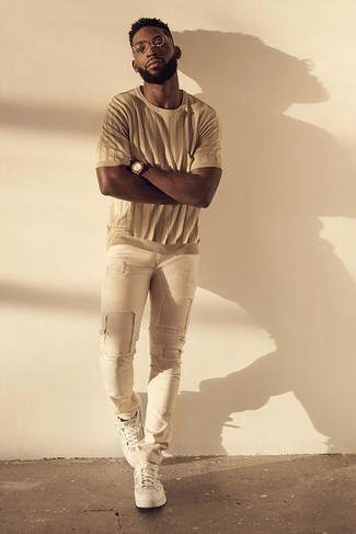 Look di Tinie Tempah: T-shirt girocollo marrone chiaro, Jeans aderenti strappati beige, Sneakers basse bianche, Orologio marrone