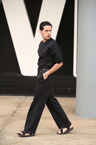 Moda uomo anni 20 quando fa molto caldo in modo rilassato: Abbina una t-shirt girocollo nera con chino neri per vestirti casual. Per un look più rilassato, prova con un paio di sandali di tela neri.