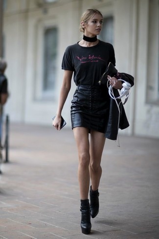 Look alla moda per donna: T-shirt girocollo stampata nera, Gonna con bottoni in pelle nera, Stivaletti in pelle pesanti neri, Girocollo nero