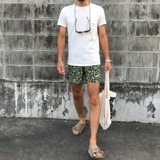 Trend da uomo 2024 quando fa molto caldo: Abbina una t-shirt girocollo bianca con pantaloncini stampati verde scuro per un look comfy-casual. Scegli un paio di sandali in pelle scamosciata beige per un tocco più rilassato.
