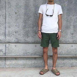 Trend da uomo 2021: Opta per una t-shirt girocollo bianca e pantaloncini verde scuro per un pranzo domenicale con gli amici. Per un look più rilassato, calza un paio di sandali in pelle scamosciata marroni.