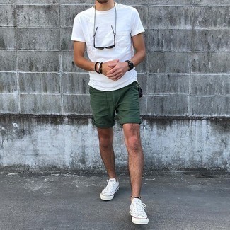 Trend da uomo 2021: Combina una t-shirt girocollo bianca con pantaloncini verde scuro per un look raffinato per il tempo libero. Un paio di sneakers basse di tela bianche si abbina alla perfezione a una grande varietà di outfit.