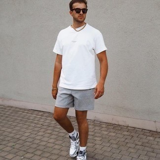 Quale pantaloncini indossare con una t-shirt girocollo bianca per un uomo di 20 anni: Punta su una t-shirt girocollo bianca e pantaloncini per un look comfy-casual. Rifinisci questo look con un paio di sneakers basse di tela grigie.
