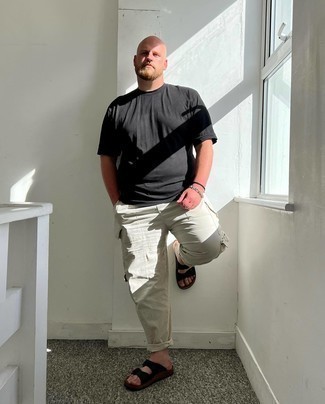 Come indossare e abbinare pantaloni cargo grigi per un uomo di 30 anni: Prova a combinare una t-shirt girocollo nera con pantaloni cargo grigi per un look comfy-casual. Opta per un paio di sandali di tela neri per avere un aspetto più rilassato.