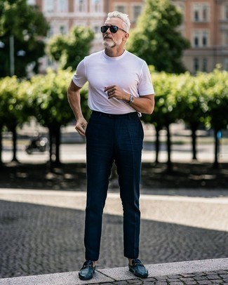 Come indossare e abbinare pantaloni eleganti blu scuro per un uomo di 50 anni: Abbina una t-shirt girocollo bianca con pantaloni eleganti blu scuro per creare un look smart casual. Opta per un paio di mocassini eleganti in pelle blu scuro per un tocco virile.