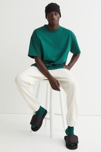Come indossare e abbinare una t-shirt girocollo verde scuro: Abbina una t-shirt girocollo verde scuro con pantaloni sportivi bianchi per un look comfy-casual. Sandali di tela neri creeranno un piacevole contrasto con il resto del look.