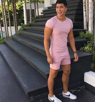 Come indossare e abbinare una t-shirt girocollo rosa in modo casual: Indossa una t-shirt girocollo rosa con pantaloncini rosa per un look raffinato per il tempo libero. Sneakers basse in pelle bianche sono una eccellente scelta per completare il look.