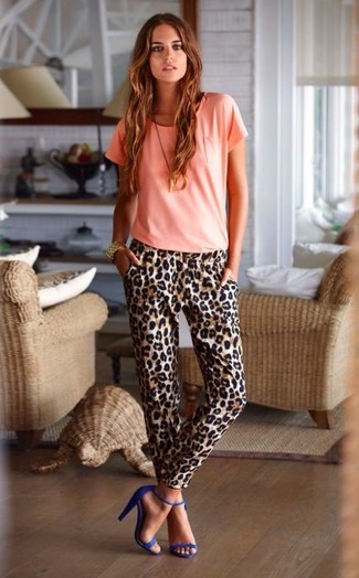 Come indossare e abbinare una t-shirt girocollo rosa in modo smart-casual: Coniuga una t-shirt girocollo rosa con pantaloni stretti in fondo leopardati marroni per essere casual. Sandali con tacco in pelle scamosciata blu sono una buona scelta per completare il look.