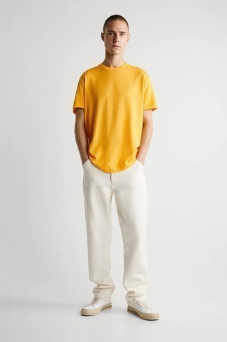 Come indossare e abbinare una t-shirt girocollo gialla: Vestiti con una t-shirt girocollo gialla e jeans bianchi per un pranzo domenicale con gli amici. Sneakers basse di tela bianche sono una valida scelta per completare il look.