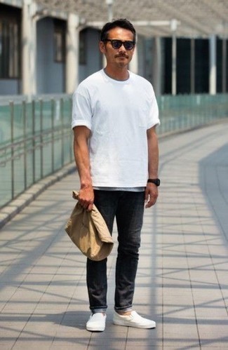 Moda uomo anni 40 in estate 2024 in modo casual: Opta per una t-shirt girocollo bianca e jeans neri per un look semplice, da indossare ogni giorno. Abbellisci questo completo con un paio di sneakers senza lacci in pelle bianche. L'outfit per questa stagione estiva è servito.