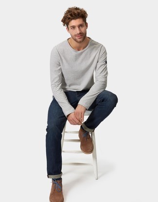 Quale jeans indossare con una t-shirt manica lunga bianca e blu scuro: Coniuga una t-shirt manica lunga bianca e blu scuro con jeans per un look perfetto per il weekend. Scegli uno stile classico per le calzature e scegli un paio di chukka in pelle scamosciata marroni.