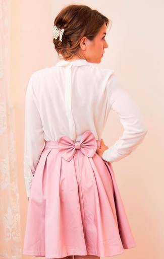 Come indossare e abbinare una minigonna rosa per una donna di 30 anni in modo smart-casual: Prova ad abbinare una t-shirt manica lunga di seta bianca con una minigonna rosa per un look semplice, da indossare ogni giorno.