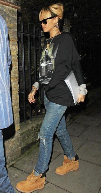 Look di Rihanna: T-shirt manica lunga stampata nera, Jeans boyfriend strappati blu, Stivali piatti stringati in nubuck marrone chiaro, Occhiali da sole neri