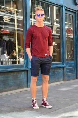 Look alla moda per uomo: T-shirt manica lunga rossa, Pantaloncini stampati blu scuro, Sneakers alte rosse e bianche, Occhiali da sole blu