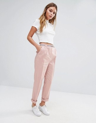 Come indossare e abbinare pantaloni rosa in modo smart-casual: Per un outfit quotidiano pieno di carattere e personalità, combina un top corto bianco con pantaloni rosa. Sfodera il gusto per le calzature di lusso e prova con un paio di sneakers basse bianche.