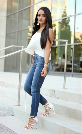 Quale jeans aderenti indossare con un top corto bianco: Prova a combinare un top corto bianco con jeans aderenti per un outfit che si fa notare. Sandali con tacco in pelle bianchi sono una gradevolissima scelta per completare il look.