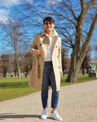 Come indossare e abbinare jeans blu per un uomo di 20 anni in modo smart-casual: Scegli un trench marrone chiaro e jeans blu per un look davvero alla moda. Sneakers basse di tela stampate bianche creeranno un piacevole contrasto con il resto del look.