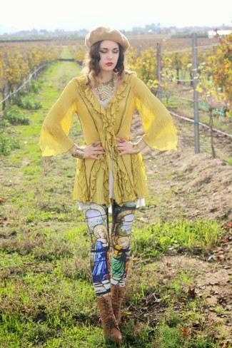 Look alla moda per donna: Tunica gialla, Leggings stampati multicolori, Stivaletti con lacci in pelle marroni, Berretto marrone chiaro