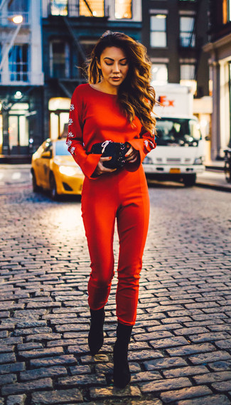 Look alla moda per donna: Tuta rossa, Stivaletti in pelle scamosciata neri, Pochette con paillettes nera