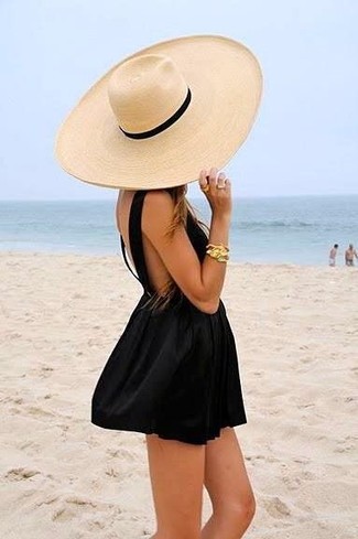Come indossare e abbinare un borsalino marrone chiaro: Combina un vestito a pieghe nero con un borsalino marrone chiaro per un'atmosfera casual-cool.
