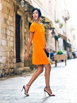 Come indossare e abbinare sandali neri e dorati in modo formale: Indossa un vestito a trapezio arancione per un look ordinato e appropriato. Mettiti un paio di sandali neri e dorati per un tocco più rilassato.