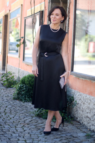Moda donna anni 50: Scegli un vestito longuette di raso nero per un fantastico look da sfoggiare nel weekend. Décolleté in pelle scamosciata neri sono una valida scelta per completare il look.