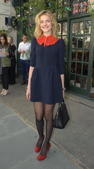 Look di Natalia Vodianova: Vestito svasato blu scuro, Décolleté in pelle rossi, Borsa shopping in pelle nera, Collant nero